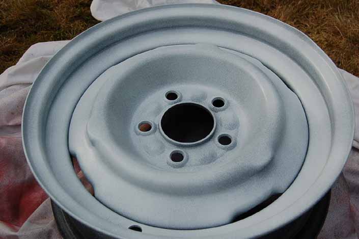 Photo shows the trailer wheel after the first 2 coats of gloss finish paint have been sprayed on